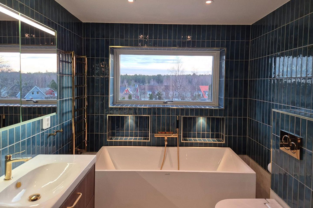 Nyrenoverat badrum med blåa väggar och stort badkar