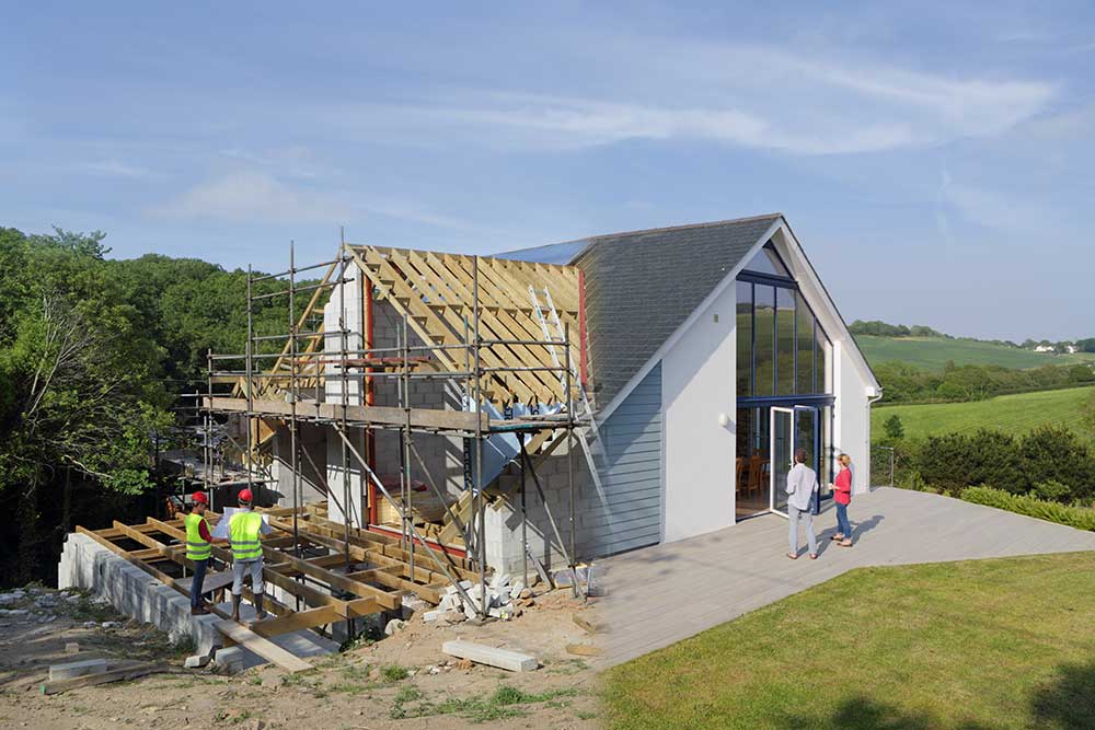 Ett modernt bostadshus under aktiv konstruktion med ställningar och exponerat trätak på ena sidan
