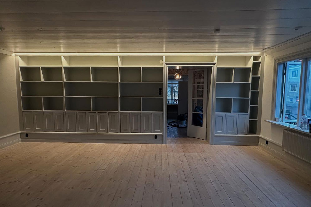 Platsbyggd bokhylla med öppna ytor och luckor