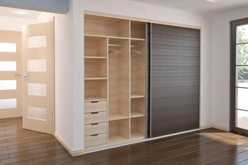 En modern inbyggd garderob med eleganta skjutdörrar i ljust trä och mörk träfinish